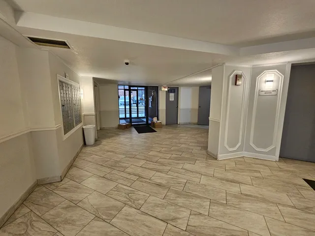 a view of a hallway with wooden floor and a living room