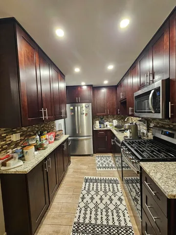 a kitchen with stainless steel appliances granite countertop a stove a sink and a refrigerator