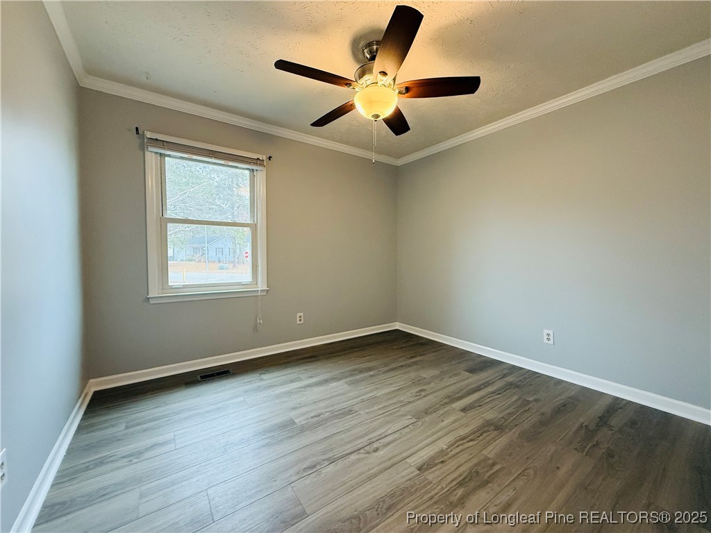 5901 Rehoboth Road Hope Mills, NC 28348 - Photo 14 of 22 an empty room with wooden floor and ceiling fan