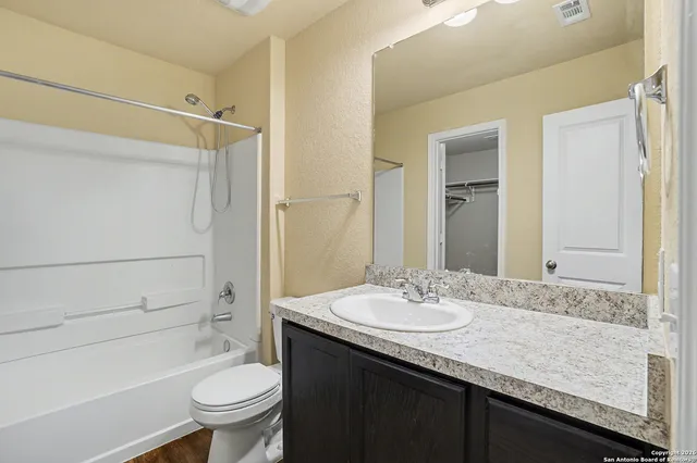 a bathroom with a granite countertop sink toilet and shower