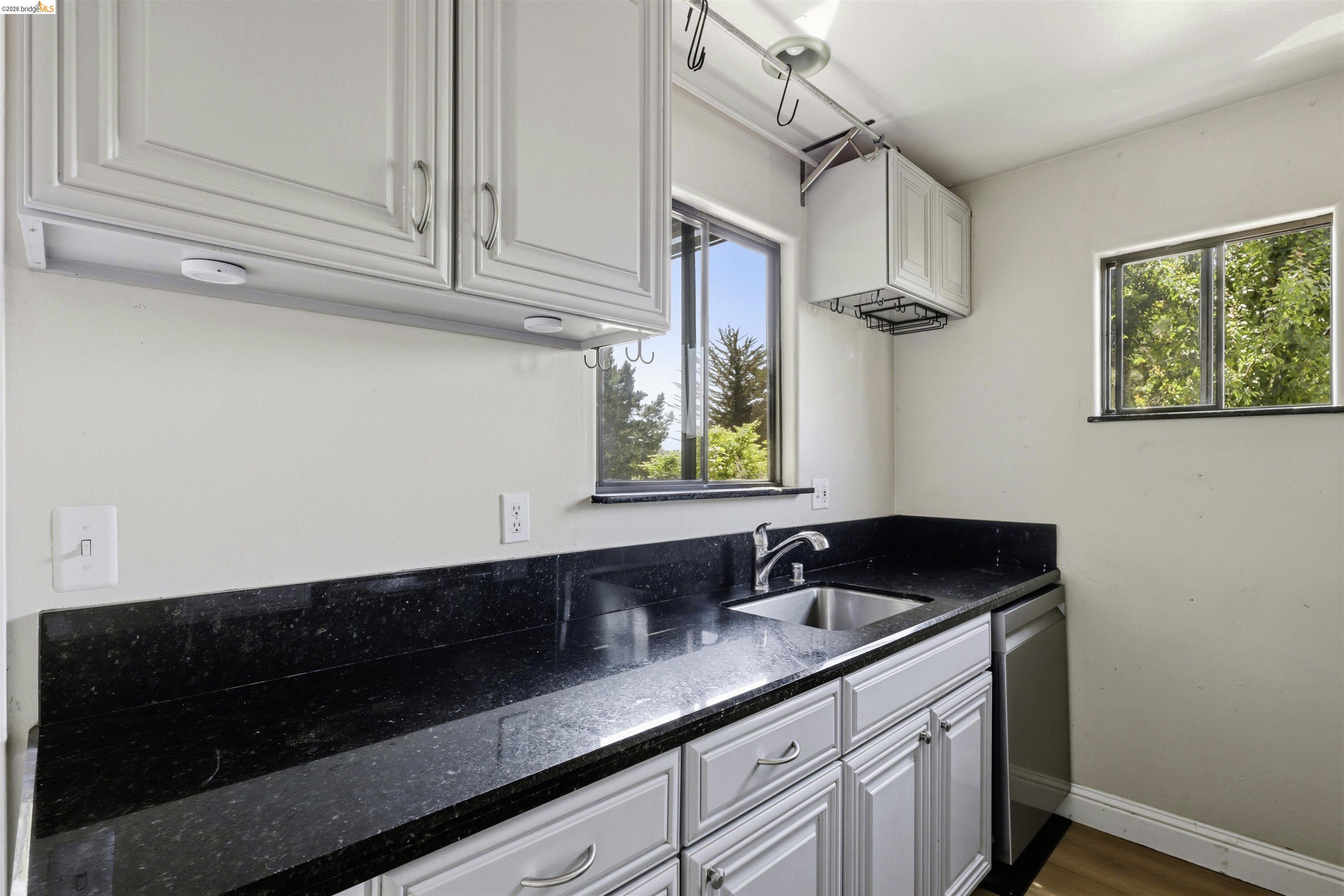 7555 Sunset Way, Unit 6 Aptos, CA 95003 - Photo 14 of 37 Kitchen area featuring light gray cabinetry, dark speckled countertops, and a stainless steel sink with a modern faucet