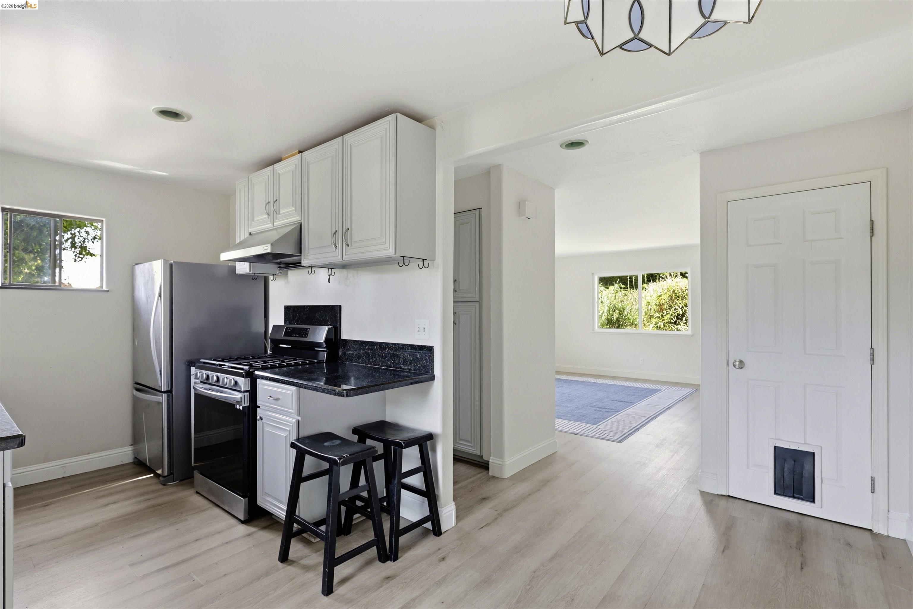 7555 Sunset Way, Unit 6 Aptos, CA 95003 - Photo 17 of 37 Modern kitchen featuring light wood-finish flooring, white cabinetry, and dark countertops