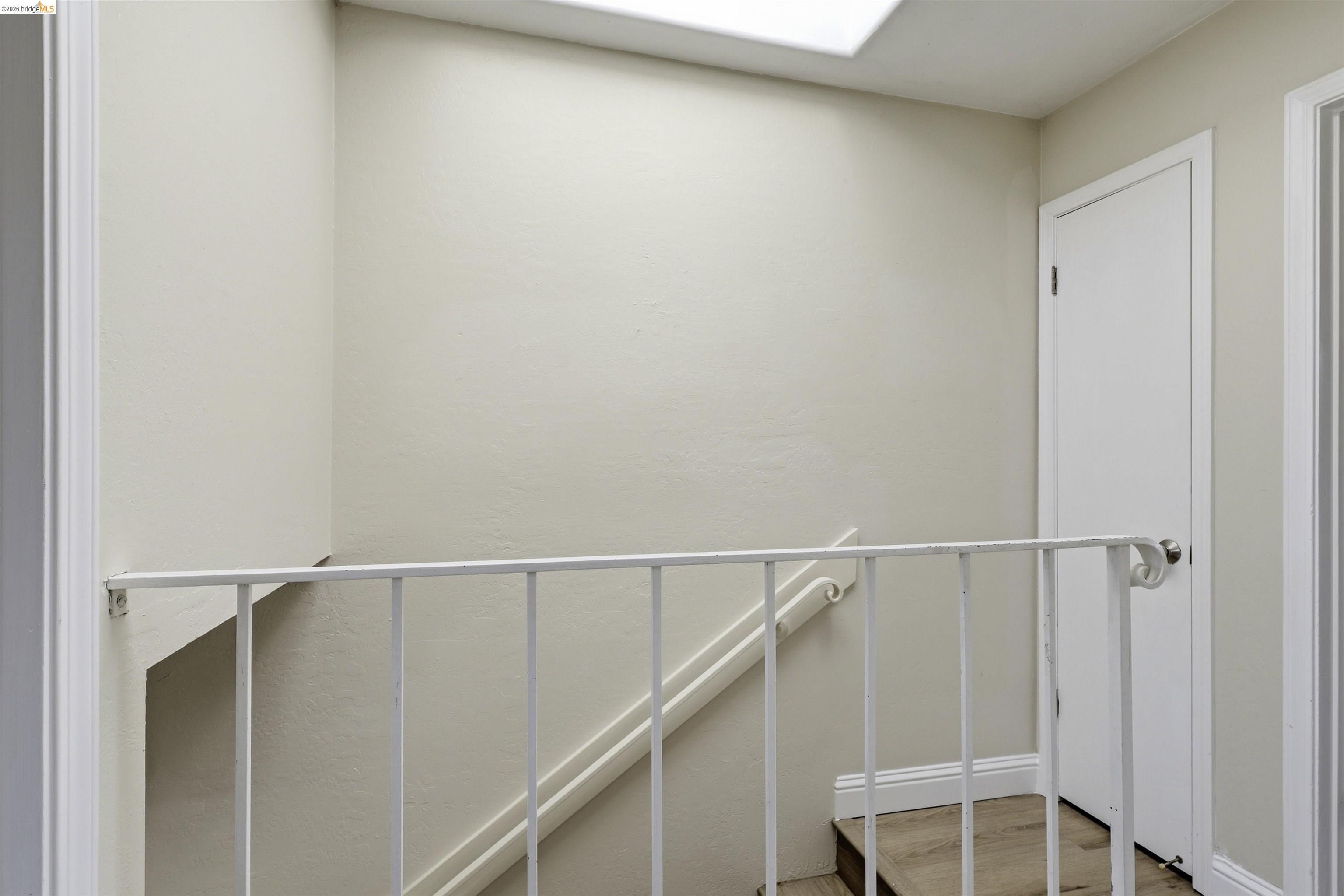 7555 Sunset Way, Unit 6 Aptos, CA 95003 - Photo 23 of 37 Stairwell with wood-finish flooring, white balustrade, and overhead skylight