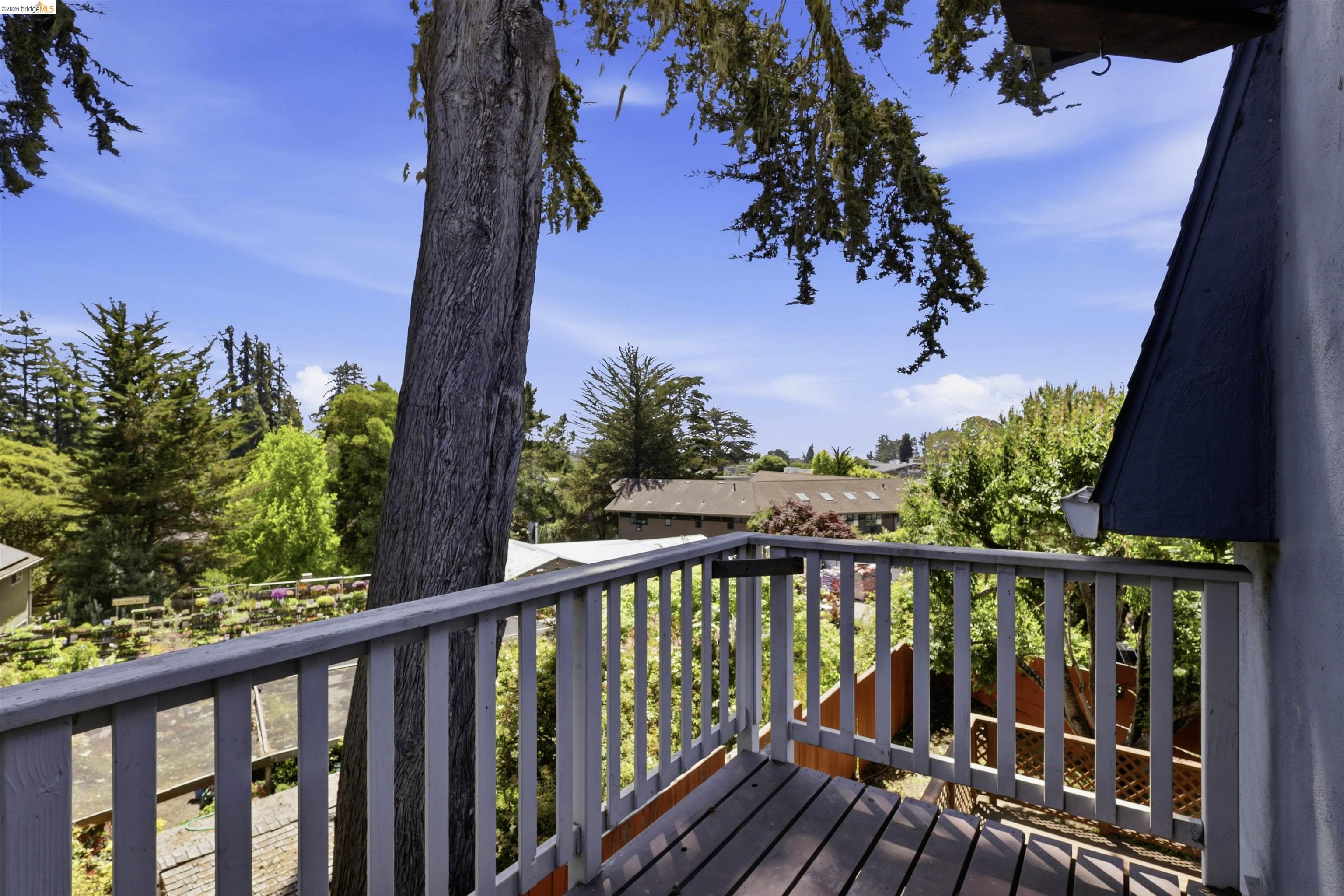 7555 Sunset Way, Unit 6 Aptos, CA 95003 - Photo 29 of 37 Outdoor deck with wood plank flooring and painted railing overlooking a treed landscape