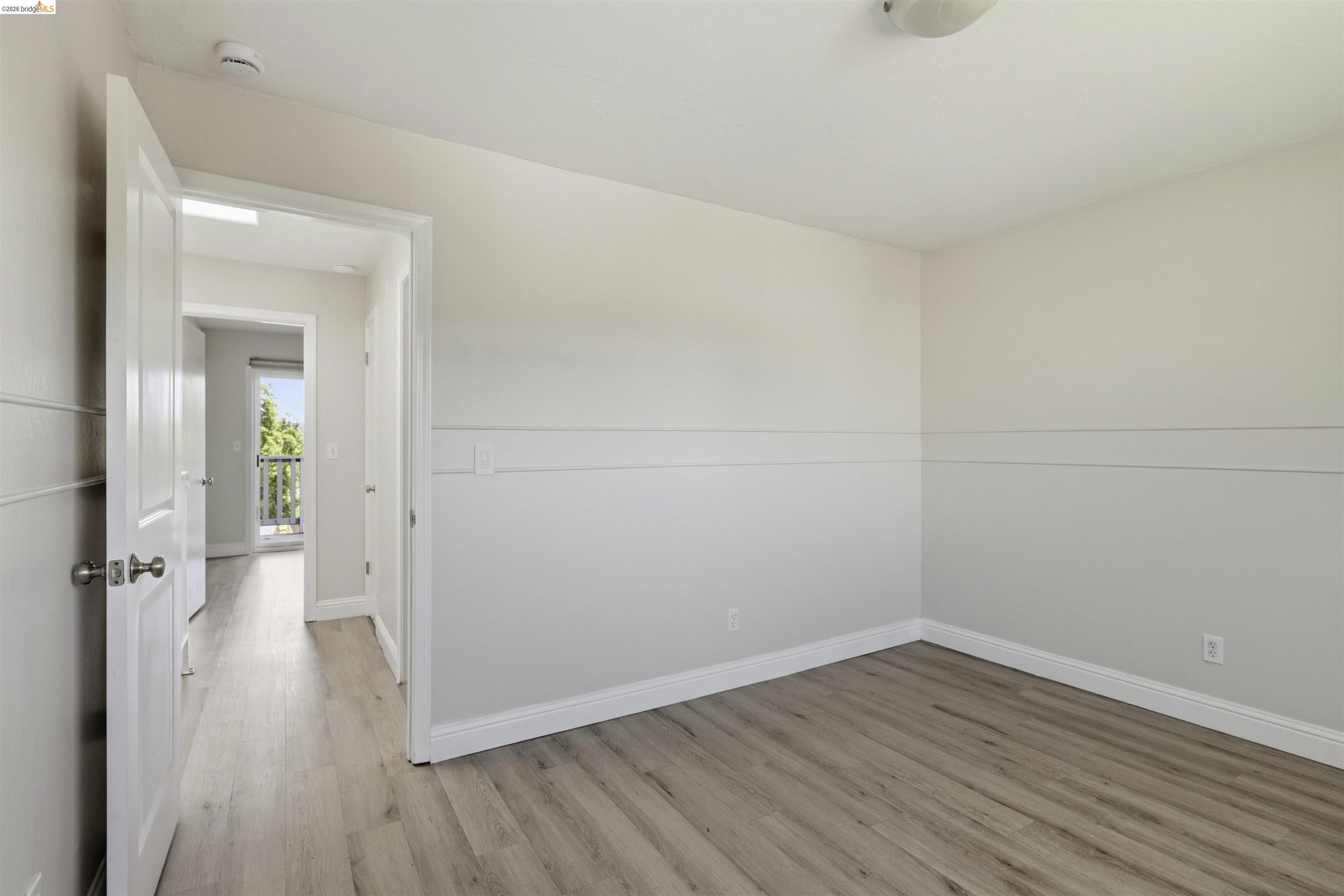 7555 Sunset Way, Unit 6 Aptos, CA 95003 - Photo 34 of 37 Bright interior space featuring wood-finish flooring, white baseboards, and a two-tone wall treatment with decorative trim