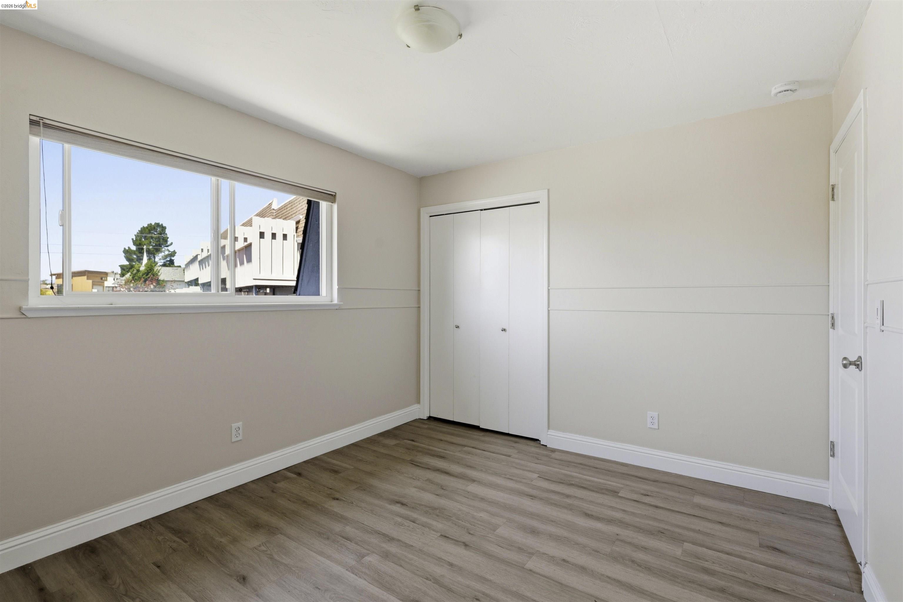 7555 Sunset Way, Unit 6 Aptos, CA 95003 - Photo 35 of 37 Spacious interior featuring wood-finish flooring, a broad window, white baseboards, and a built-in closet with bifold doors