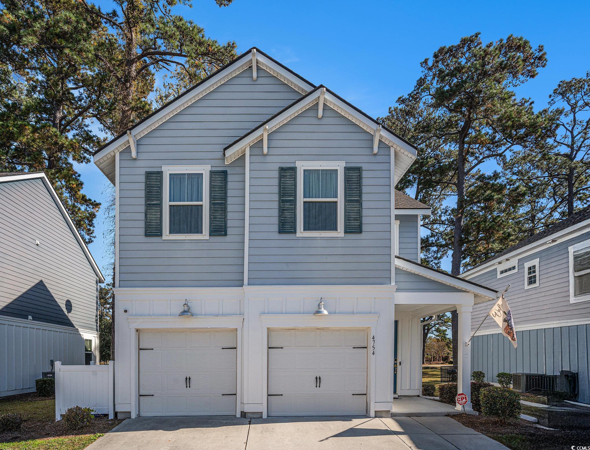 View of front of house with concrete driveway, an attached garage, and board and batten siding