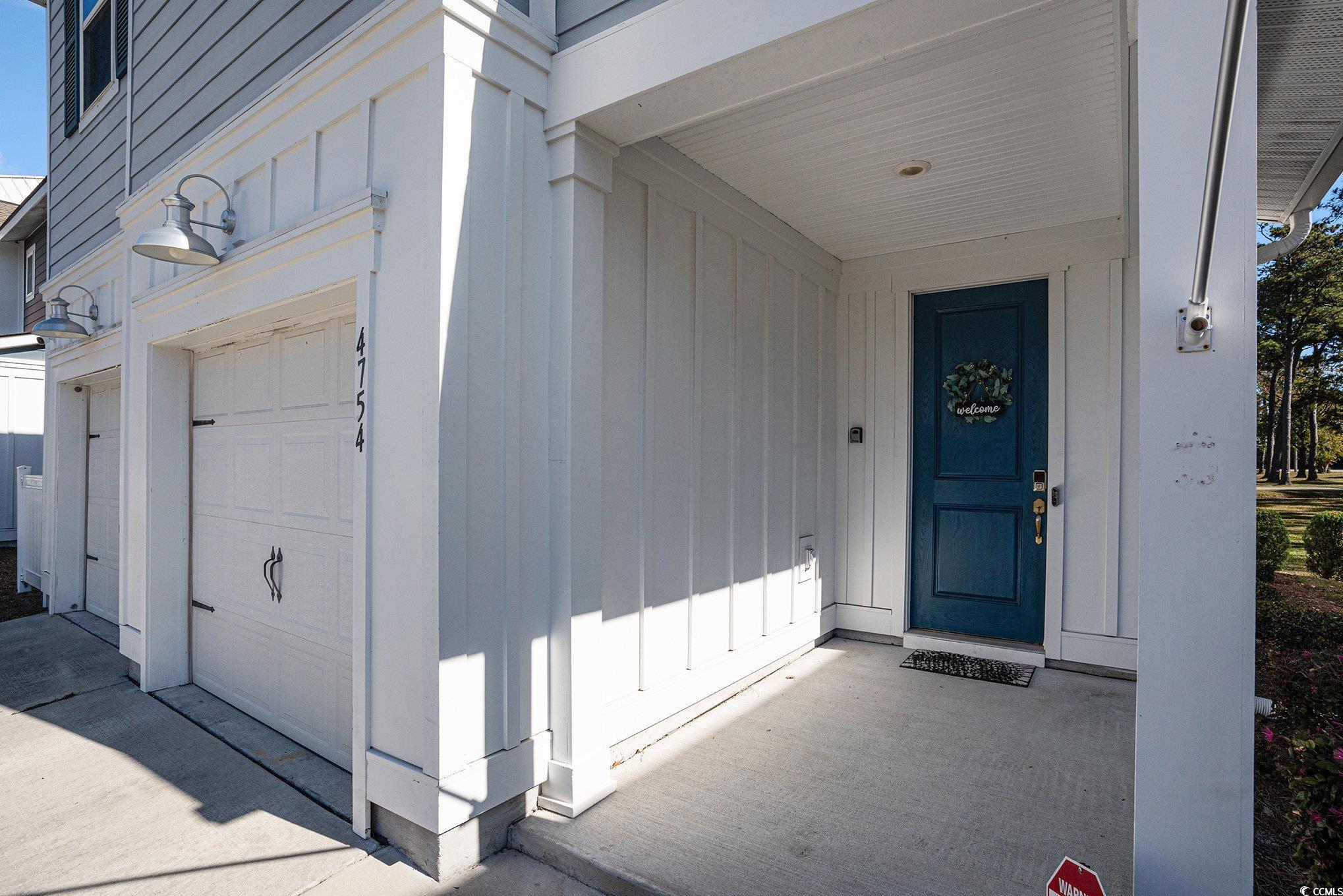 4754 Cloisters Lane Myrtle Beach, SC 29577 - Photo 28 of 32 Doorway to property with a garage, covered porch, and board and batten siding