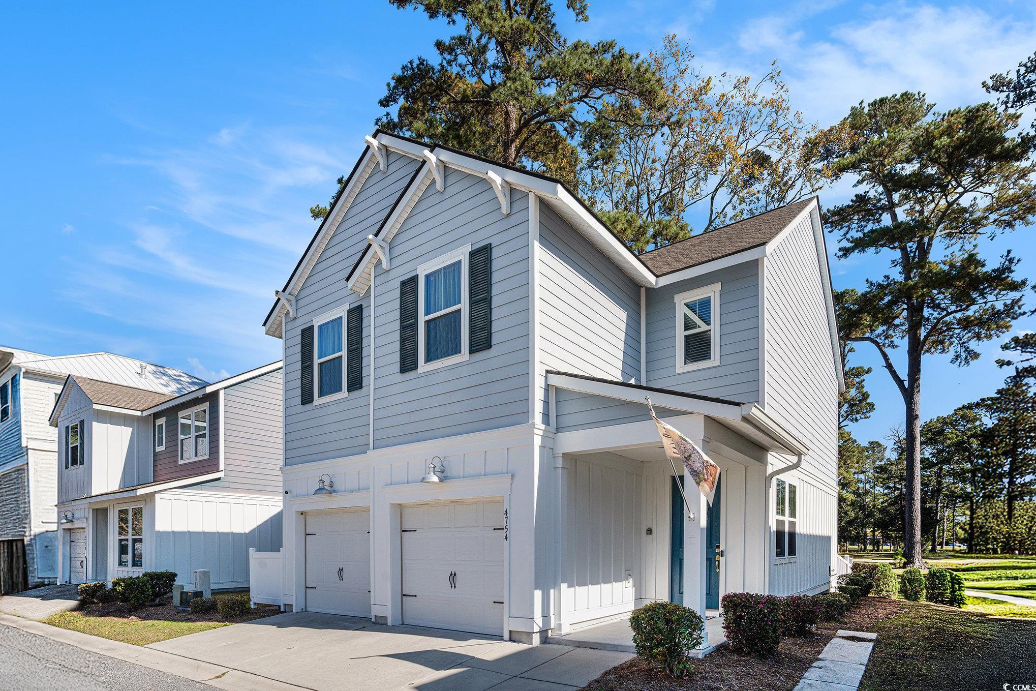 4754 Cloisters Lane Myrtle Beach, SC 29577 - Photo 3 of 32 View of side of home with board and batten siding, an attached garage, concrete driveway, and a shingled roof