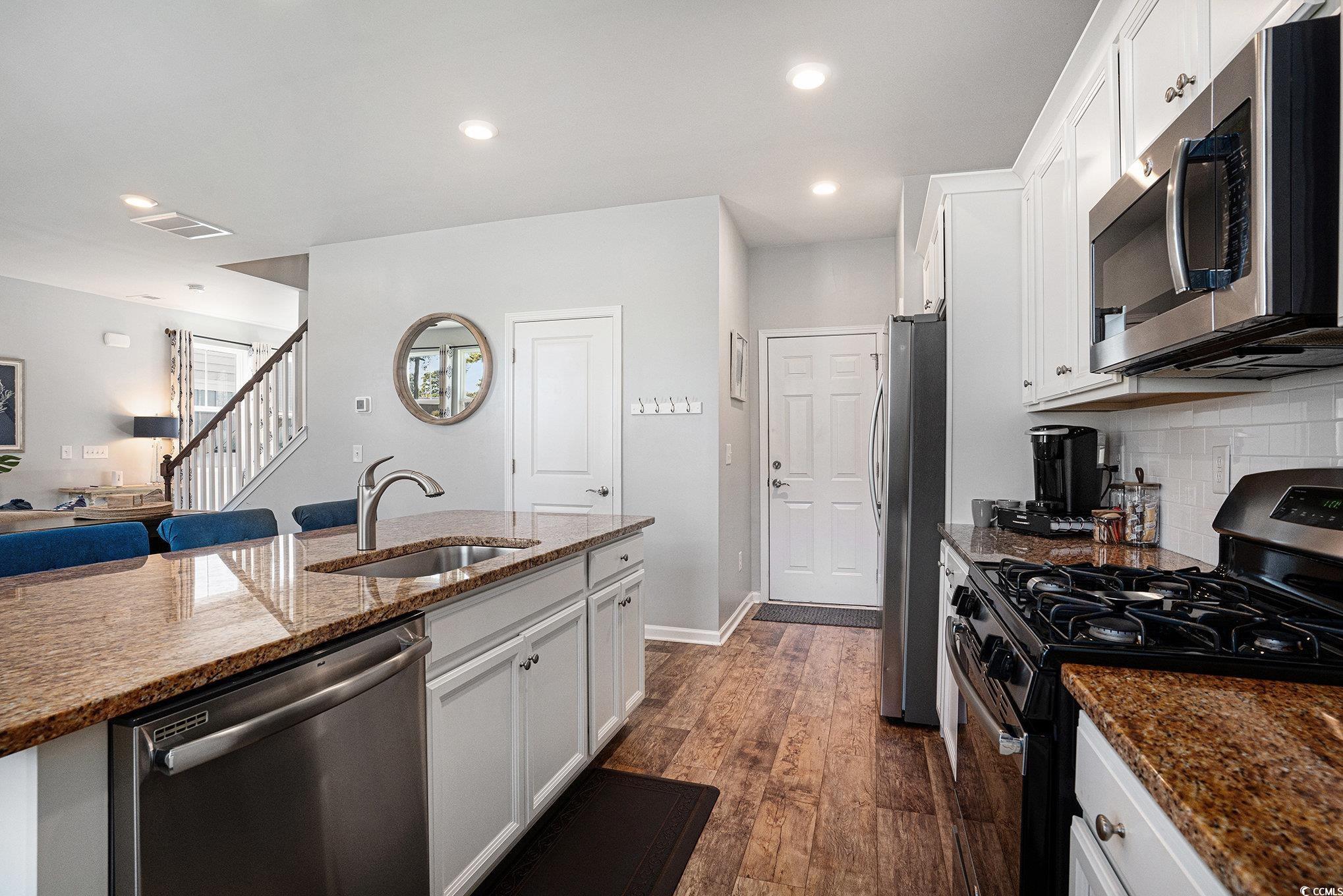 4754 Cloisters Lane Myrtle Beach, SC 29577 - Photo 10 of 32 Kitchen featuring appliances with stainless steel finishes, white cabinets, dark wood-style floors, dark stone countertops, and recessed lighting