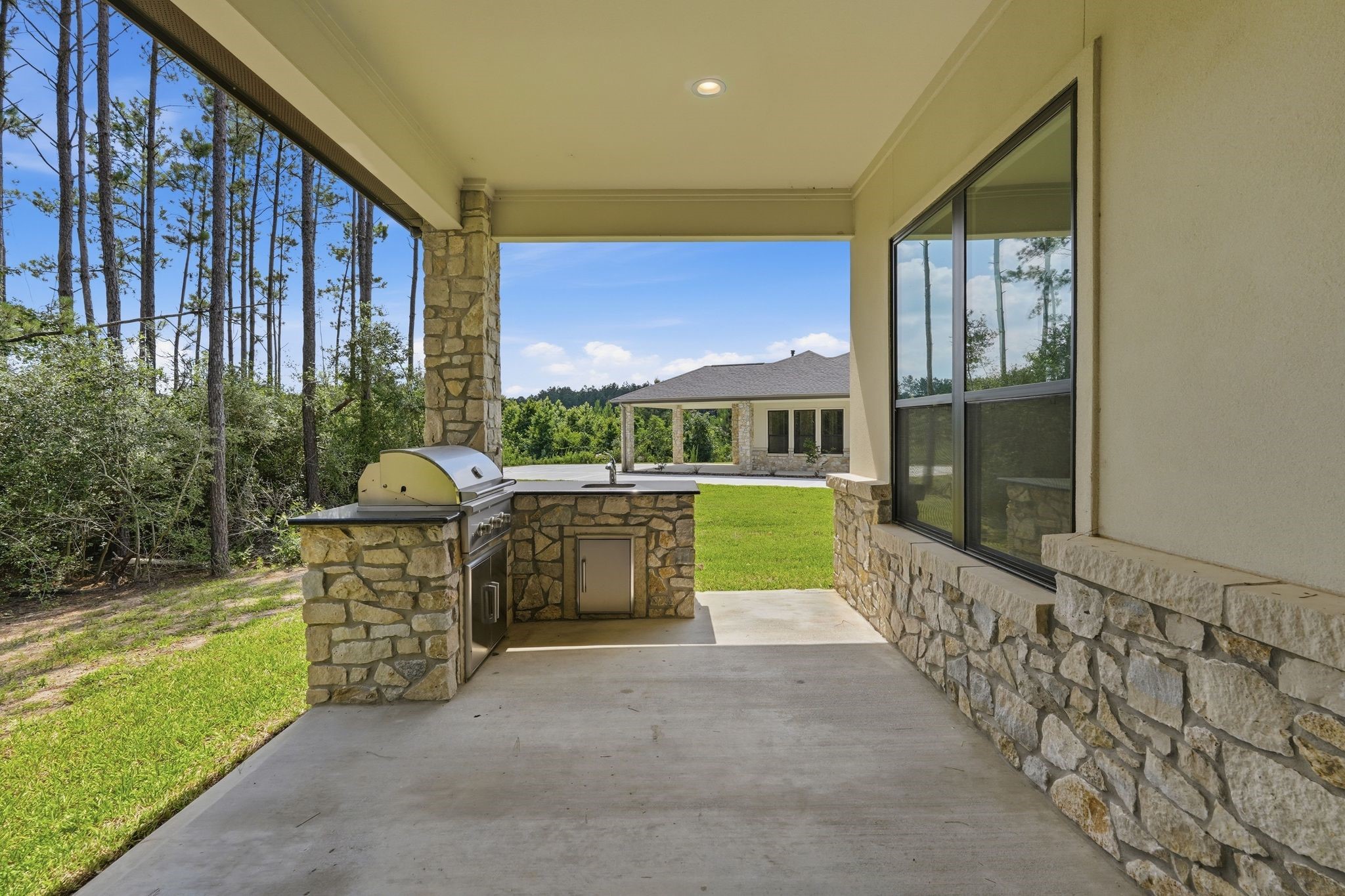 16081 Forest Mill Road Willis, TX 77378 - Photo 29 of 37 Your private outdoor retreat awaits with a spacious screened patio, built-in outdoor kitchen, and tranquil wooded views—perfect for morning coffee, weekend gatherings, and everything in between.