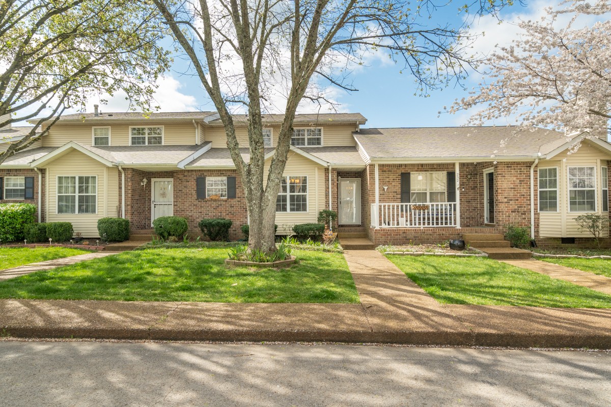 front view of a brick house with a yard