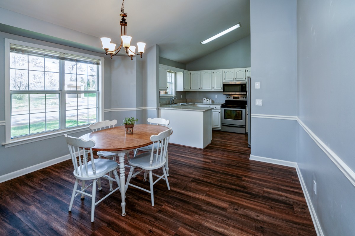 234 Pepper Ridge Circle Antioch, TN 37013 - Photo 8 of 28 a dining room with wooden floor a chandelier a wooden table and chairs