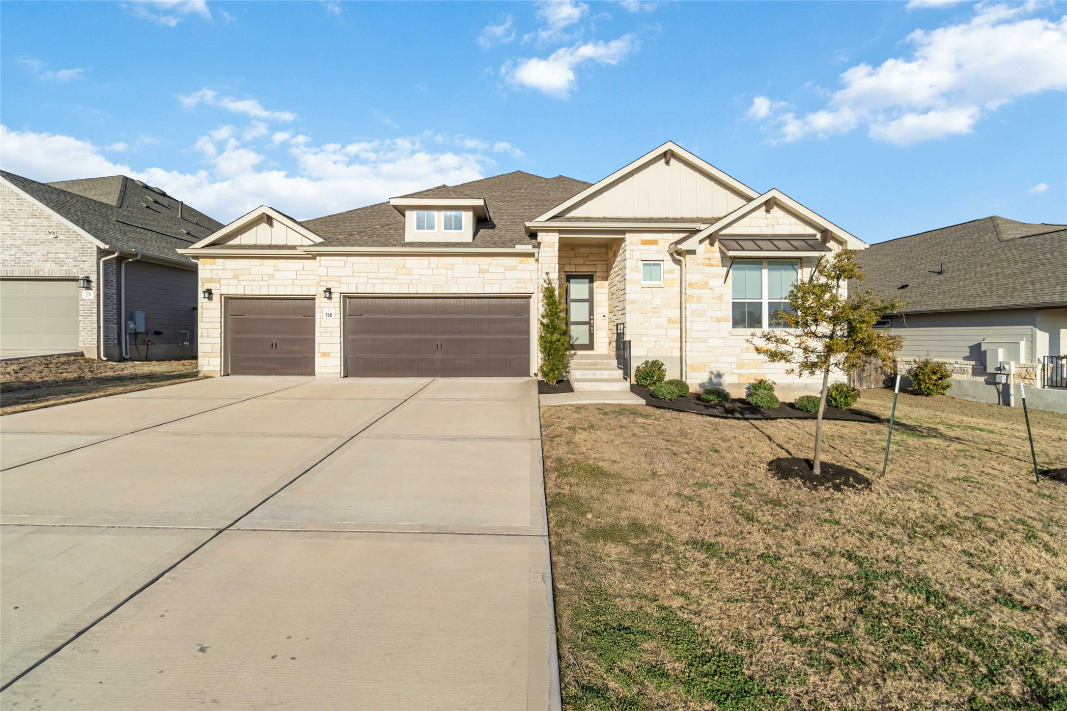 158 Sumter Way Kyle, TX 78640 - Photo 2 of 38 a view of a white house with a yard and table and chairs under an umbrella