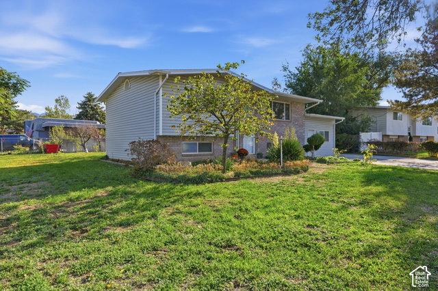 1127 Electra Lane Sandy, UT 84094 - Photo 2 of 27 Exterior featuring light gray siding, brick accents, and a landscaped front yard with mature plantings