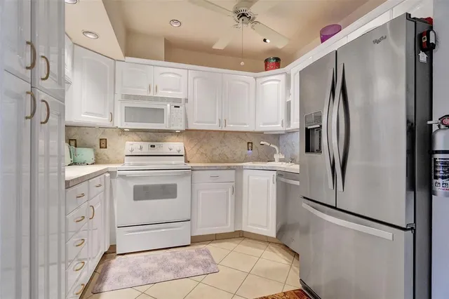 a large kitchen with stainless steel appliances granite countertop a refrigerator and a sink