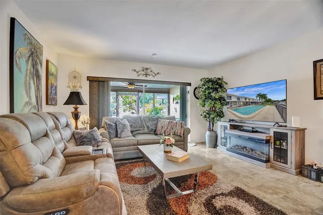 a living room with furniture a flat screen tv and a large window