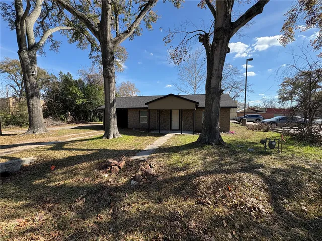 a view of a house with backyard and tree