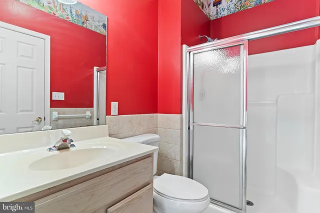 a bathroom with a sink vanity mirror and toilet