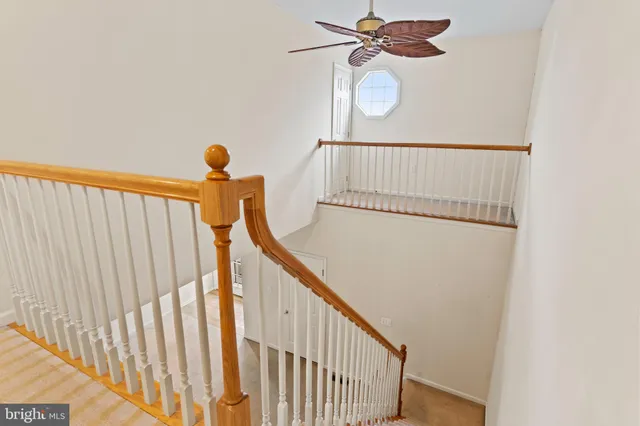 a view of staircase with railing and white walls