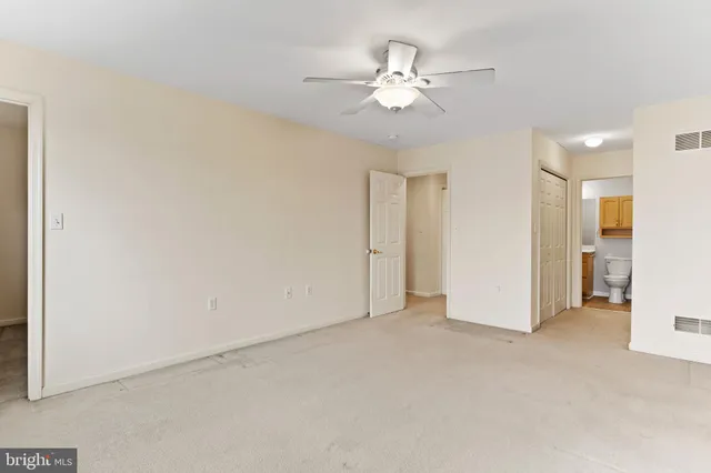 a view of an empty room with a chandelier fan