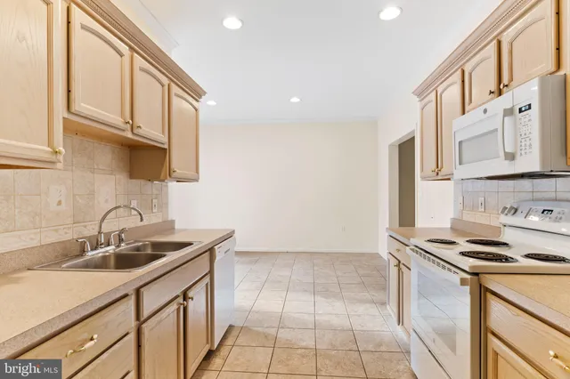 a kitchen that has a sink a stove and cabinets