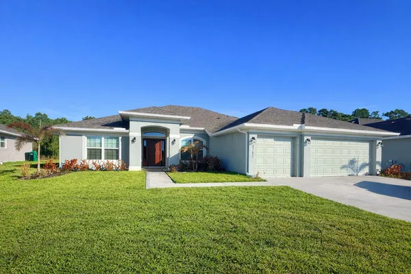 a front view of a house with a yard and trees