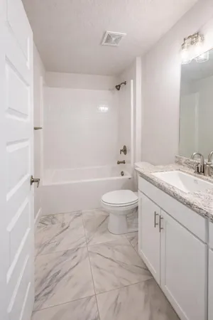 a bathroom with a granite countertop sink mirror and a bathtub
