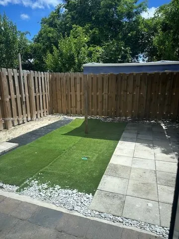 a view of backyard with wooden fence