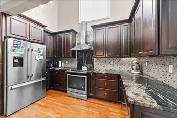 a kitchen with granite countertop a refrigerator stove and cabinets