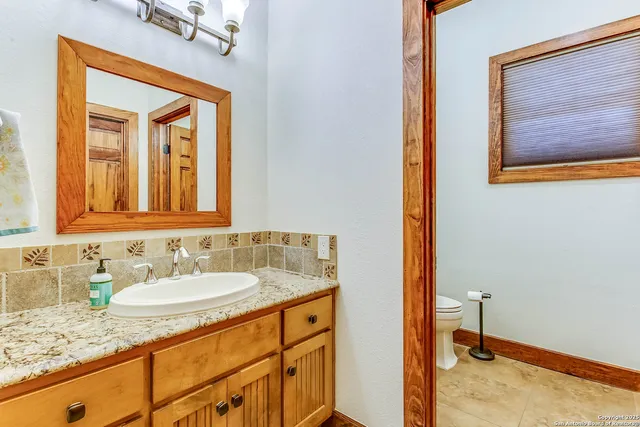 a bathroom with a granite countertop sink vanity and mirror