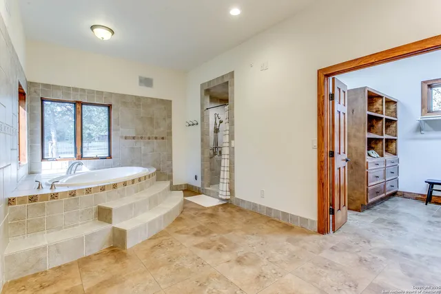 a spacious bathroom with a tub and a window