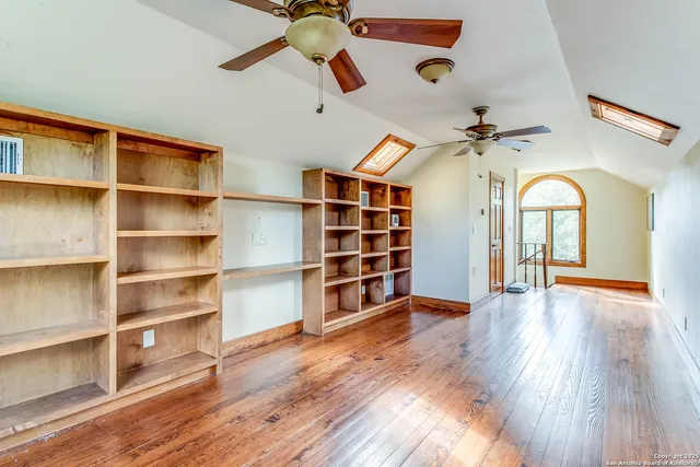 a view of a room with wooden floor and lots of shelves