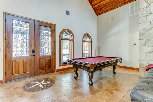 a room with pool table and windows