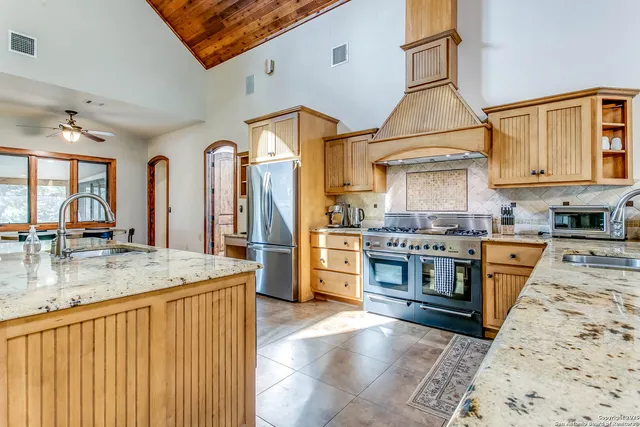 a kitchen with stainless steel appliances granite countertop a stove a sink and a refrigerator