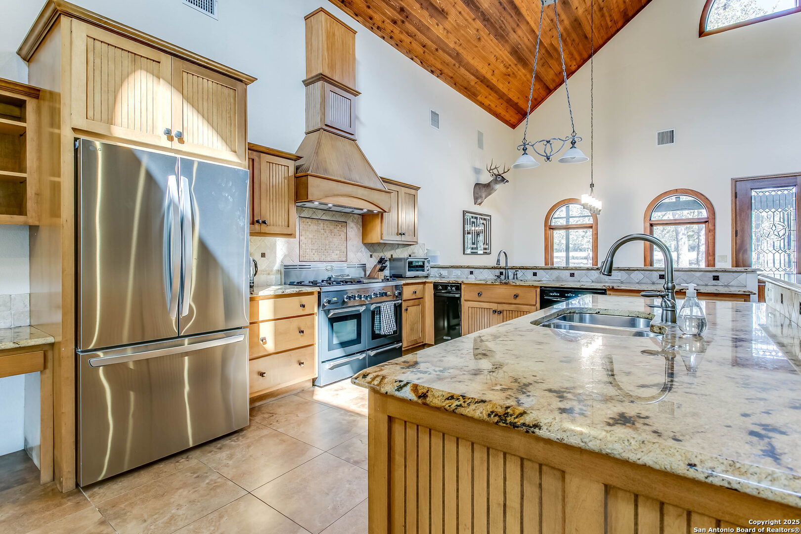 408 Copeland Hill Road Smithville, TX 78957 - Photo 10 of 35 a kitchen with stainless steel appliances granite countertop a refrigerator a stove and a sink with wooden floor