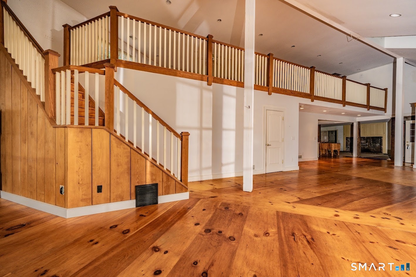 19 High Street Middlefield, CT 06455 - Photo 11 of 18 Striking open-concept design features soaring ceilings, an impressive open staircase, expansive second-story loft, and beautiful wide-plank pine floors that bring warmth and character throughout.
