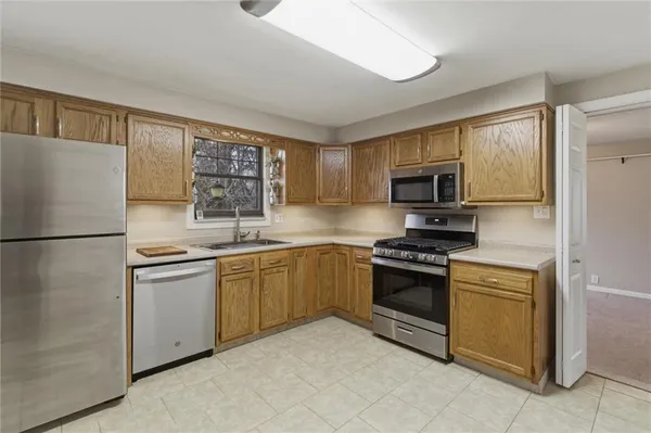 a kitchen with stainless steel appliances granite countertop a refrigerator stove a sink dishwasher and microwave