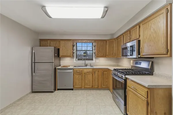 a kitchen with stainless steel appliances granite countertop a refrigerator sink and stove