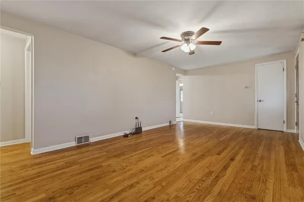 a view of an empty room with wooden floor