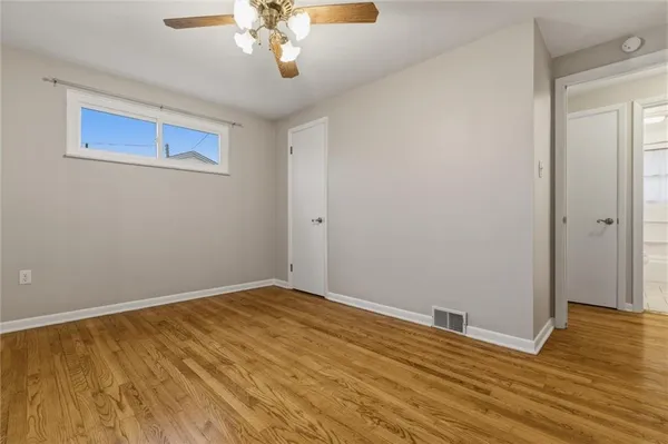 a view of an empty room with wooden floor