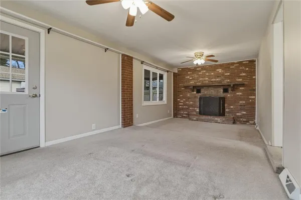 a view of an empty room with a fireplace and a window
