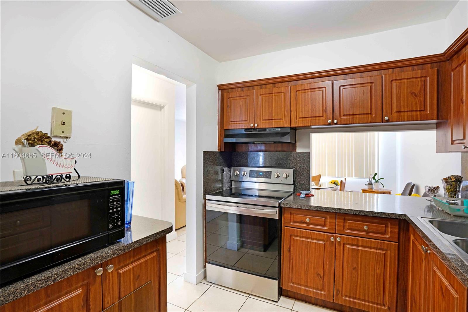 624 Northwest 11th Street Miami, FL 33136 - Photo 18 of 26 a kitchen with granite countertop a stove top oven microwave and cabinets