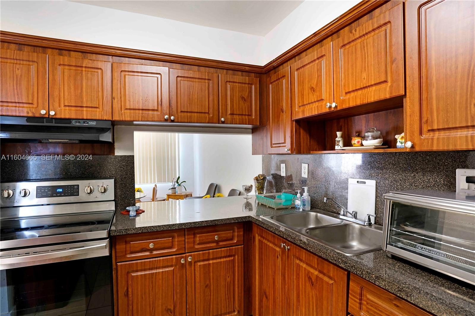 624 Northwest 11th Street Miami, FL 33136 - Photo 22 of 26 a kitchen with stainless steel appliances granite countertop a stove a sink and a microwave