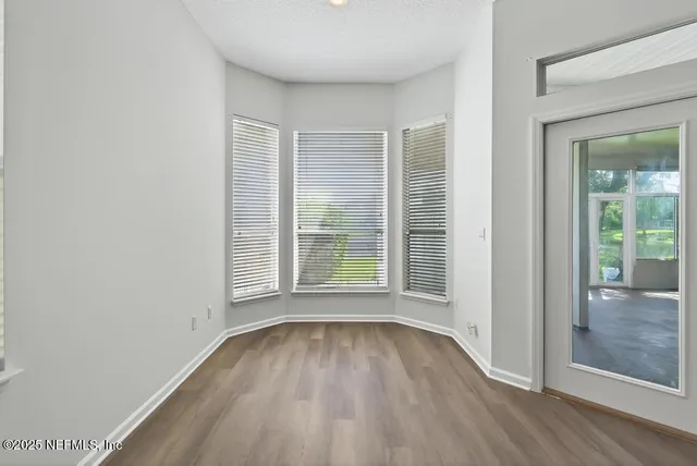 a view of a room with wooden floor and window