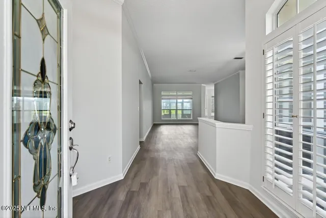 a view of a room with a large window and wooden floor