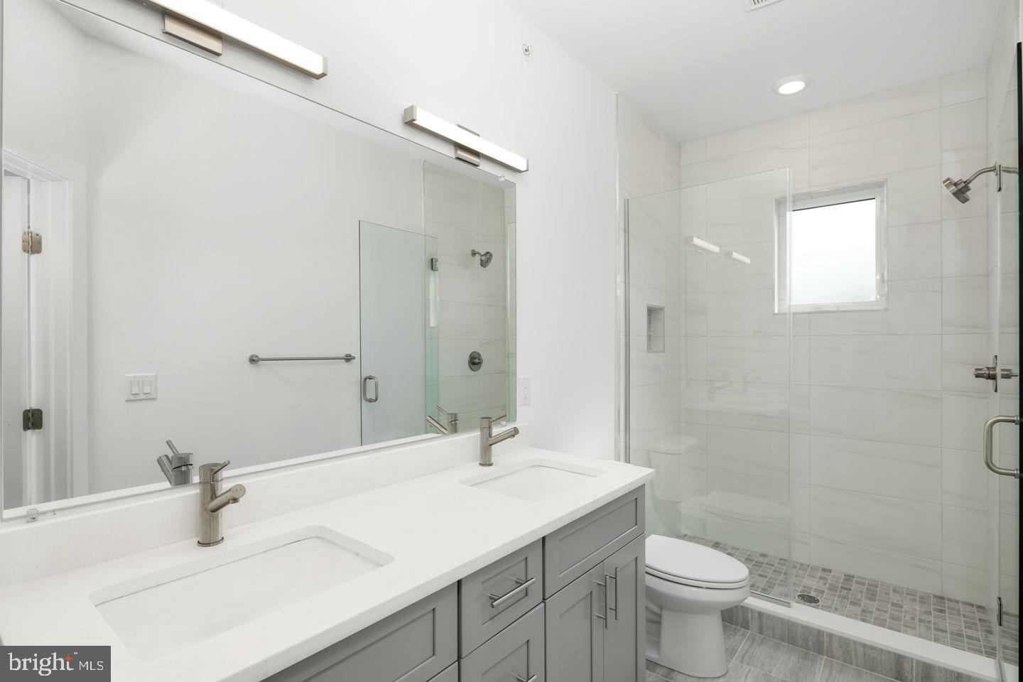 2721 Federal Street, Unit 3 Philadelphia, PA 19146 - Photo 16 of 22 a bathroom with a sink toilet a mirror and shower