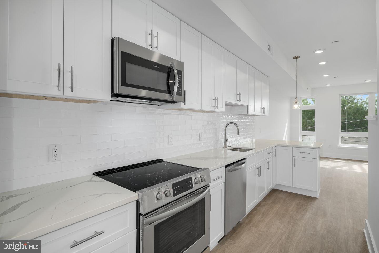 2721 Federal Street, Unit 3 Philadelphia, PA 19146 - Photo 2 of 22 a kitchen with white cabinets stainless steel appliances and sink