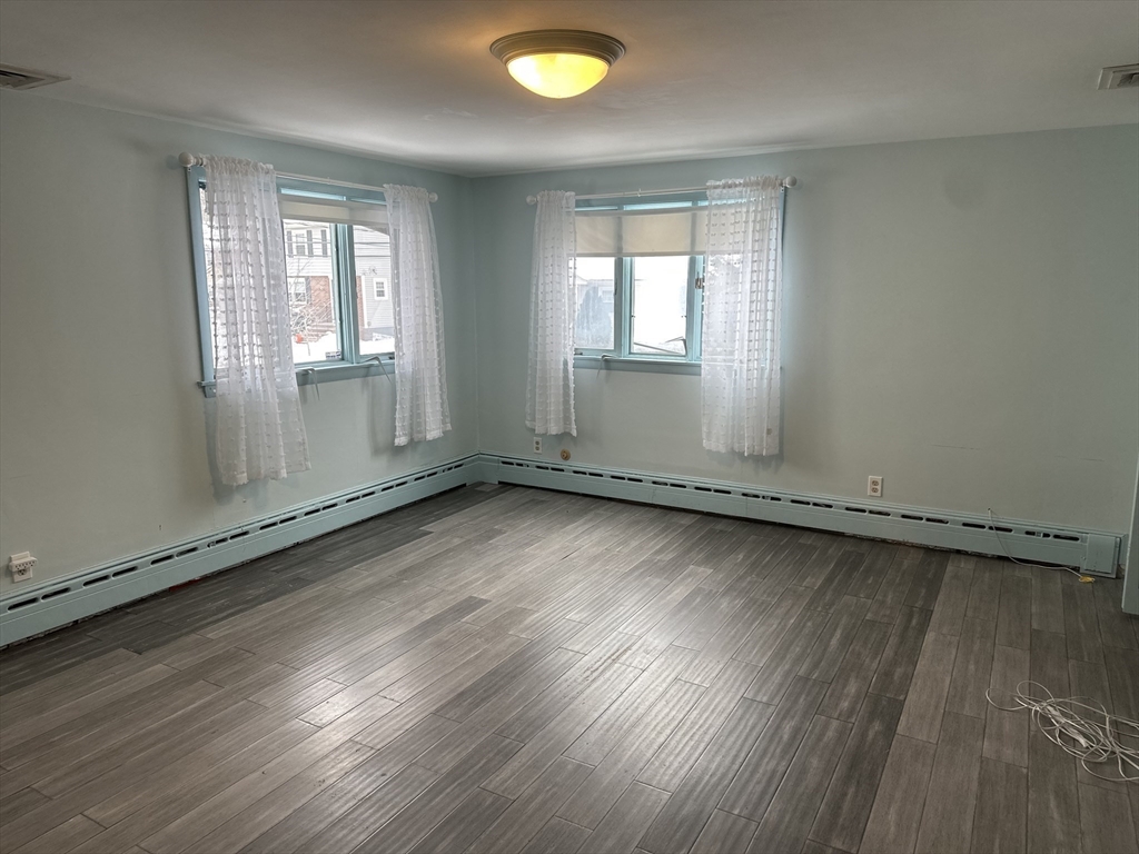 101 Hackensack Road Boston, MA 02467 - Photo 13 of 33 an empty room with wooden floor and windows