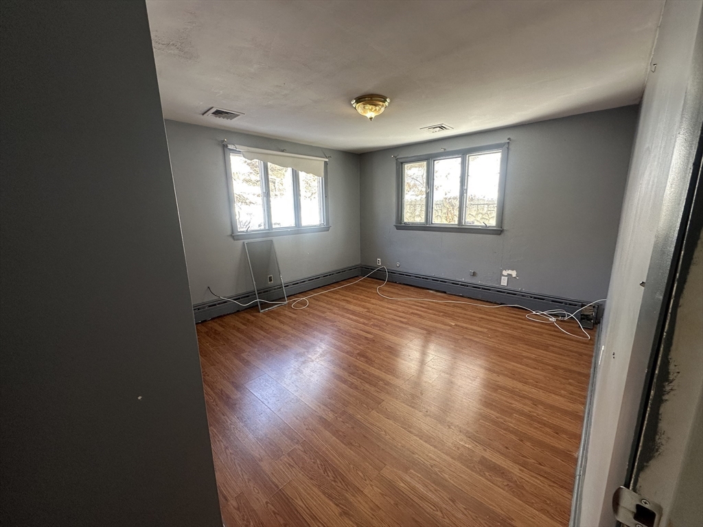 101 Hackensack Road Boston, MA 02467 - Photo 22 of 33 an empty room with wooden floor and windows